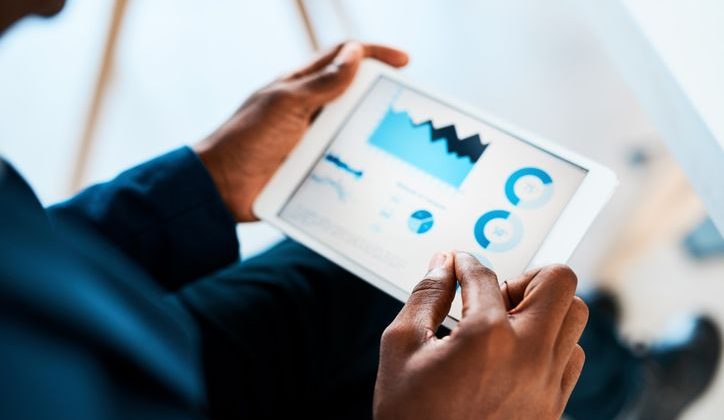 Businesswoman using a tablet with business data on it in an office.