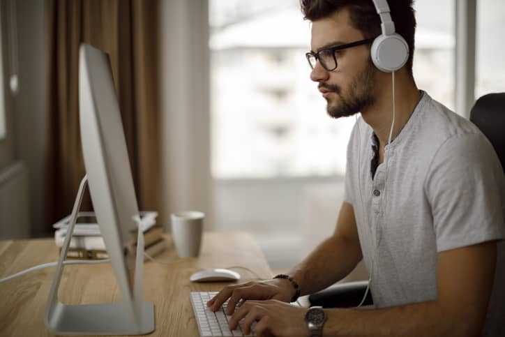 Young man working on computer at home.
