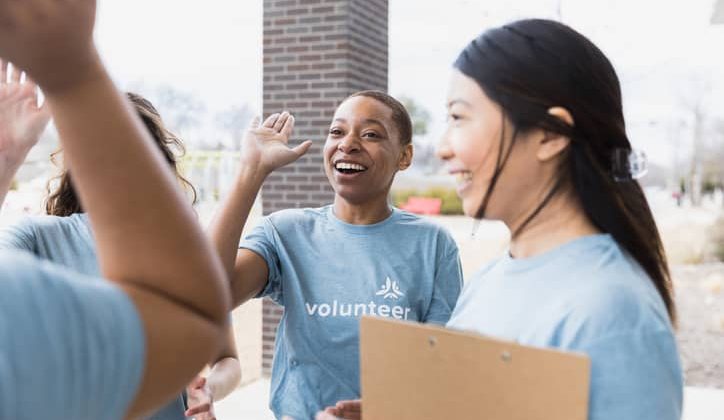 Young adult volunteers celebrating a successful event.